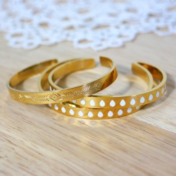 Bracelets rigides en métal doré gravé et émaillé de gouttes blanches